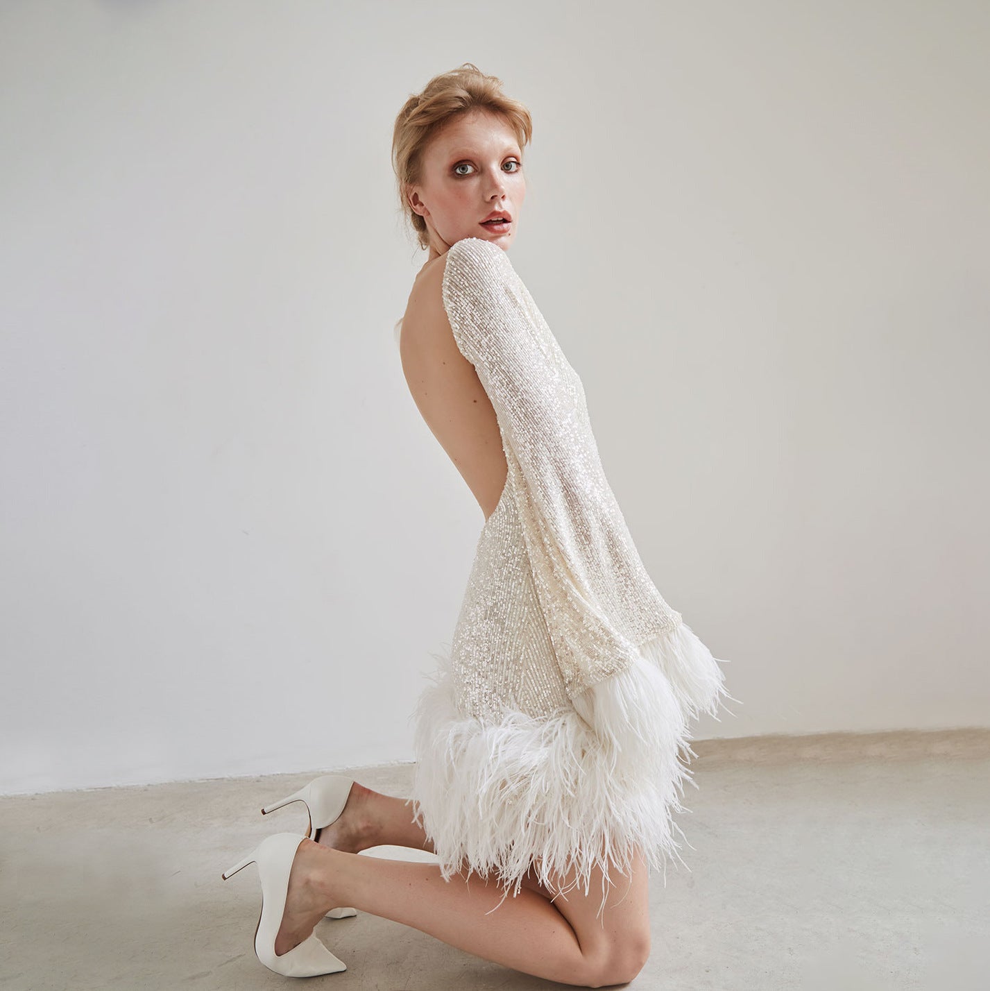 Women's waist-cinching short dress with plunging back, long sleeves, sequins and feathers